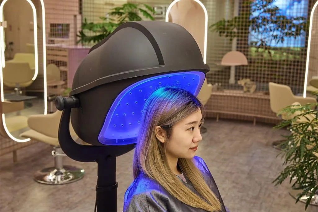 A client under LED blue light therapy after the microneedling procedure