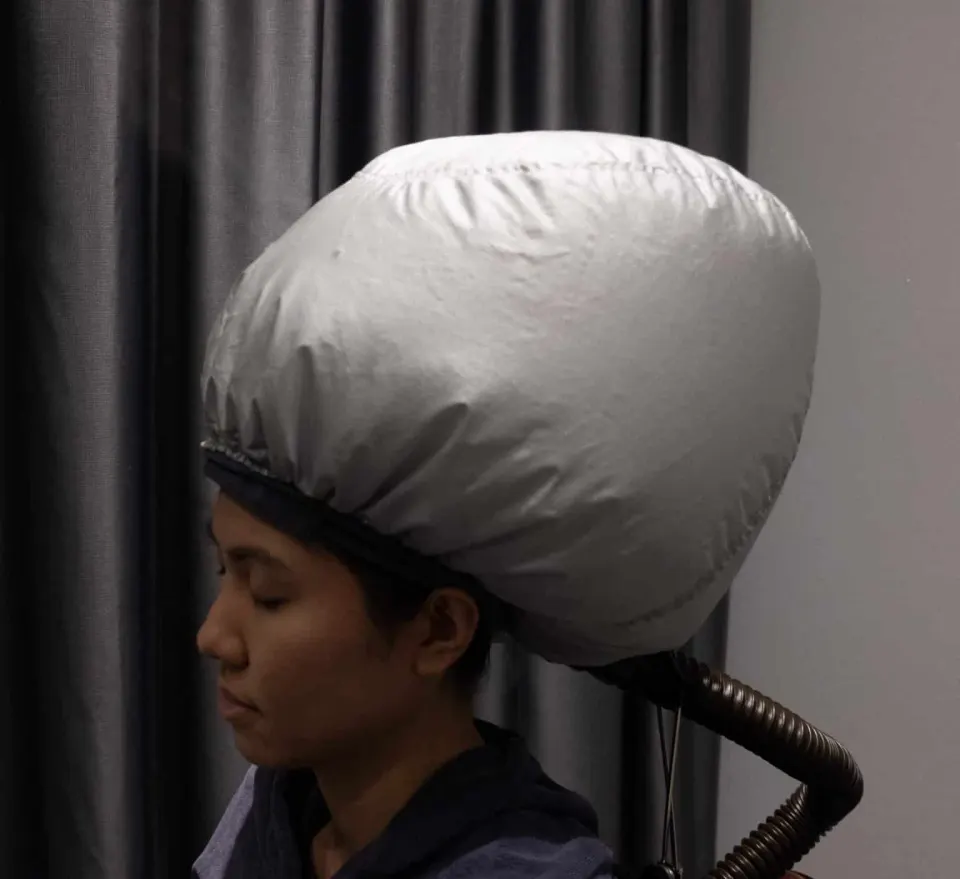 A client receiving O3 steaming during the anti-hair loss mask treatment